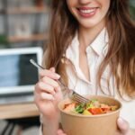 Une femme terminant un repas équilibré. Glucavit